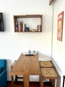 een houten tafel in een woonkamer met een blauwe bank bij Nice & Cozy Little Studio with Terrace in Estoril in Estoril