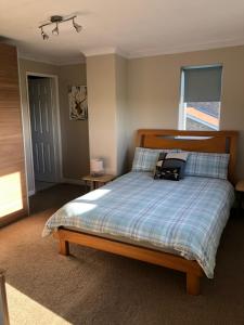 1 dormitorio con 1 cama con cabecero de madera en Number One - Fully Equipped Self Catering Four Bedroom House next to Dunedin, 15 mins to Spurn, 20 mins to Saltend, 12 mins to Easington, en Patrington