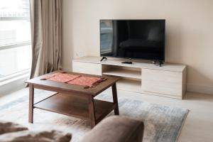 a living room with a tv and a coffee table at Classy 1BR in Al Sahab Dubai Marina in Dubai