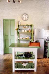 a kitchen with a table and a refrigerator at Die Dam Huis in Nieu-Bethesda