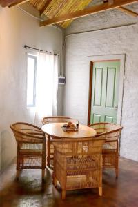 a table and chairs in a room with a green door at Die Dam Huis in Nieu-Bethesda