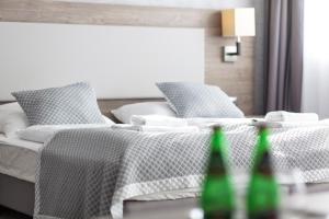 two beds in a room with two green bottles at Grand Laola Spa in Pobierowo