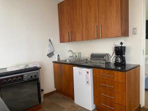 a kitchen with wooden cabinets and a white refrigerator at Silver Linings Cottage in Parys