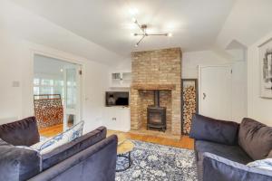 a living room with two couches and a fireplace at Pass the Keys Lovely Countryside Coach Cottage in Tonbridge