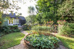 a garden with a flower bed in front of a house at Pass the Keys Lovely Countryside Coach Cottage in Tonbridge