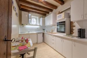 a kitchen with white cabinets and a table in it at La Reverdie Escapade aux pays des châteaux in Cellettes