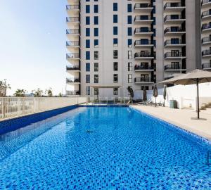 a swimming pool in front of a building at Voyage Studio In Waters Edge in Abu Dhabi