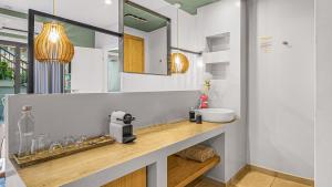 een badkamer met een wastafel en een spiegel bij Sunshine Boutique Hotel in Malia