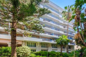 an apartment building with trees in front of it at Résidence Pierre & Vacances Les Rivages Du Parc in Menton