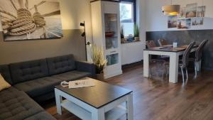 een woonkamer met een bank en een tafel bij Ferienhaus-Kegelrobbe in Dornumersiel