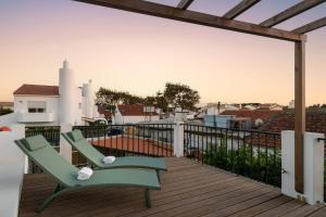 a green chair sitting on a deck with a view at Sea´ya Thoughtful Stays - Villa Areia in Cascais