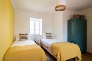 a bedroom with two beds and a green cabinet at Sea´ya Thoughtful Stays - Villa Areia in Cascais