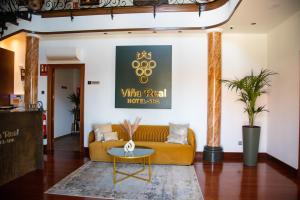 sala de estar con sofá amarillo y mesa en Hotel Spa Viña Real en Arévalo