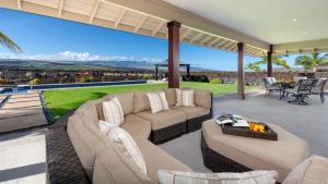een patio met een bank en een vuurplaats bij ADVENTURE AWAITS Fun 4BR Ainamalu Home with Private Pool in Waikoloa
