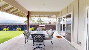 een eetkamer met een tafel en stoelen op een patio bij ADVENTURE AWAITS Fun 4BR Ainamalu Home with Private Pool in Waikoloa