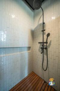 eine Dusche im Bad mit Holzboden in der Unterkunft Villa Kyuss - by Unicorn Villas Bali in Canggu