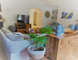 a living room with a couch and a table with a plant at Fashion Villa in Vilamoura with Private Pool in Quarteira