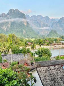 Blick auf ein Dorf mit Bergen im Hintergrund in der Unterkunft Hana Riverside Hotel in Vang Vieng