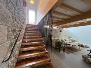 a staircase in a house with a stone wall at El Pecu Casa Rural in Bustillo del Páramo