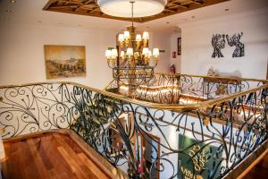 una escalera en una casa con una lámpara de araña en Hotel Spa Viña Real en Arévalo