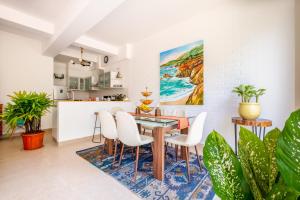 a dining room with a table and white chairs at El Rocio by The Blue Kite - 2BHK Apartments in Assagao with Common pool, Free Parking, 8 min away from Vagator Beach in Assagao +171 photos