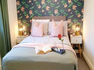 a bedroom with a bed with a book and a flower at Pass the Keys Beautifully refurbished house close to Airport in Manchester