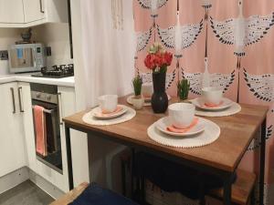 a kitchen with a wooden table with cups and saucers at Pass the Keys Beautifully refurbished house close to Airport in Manchester