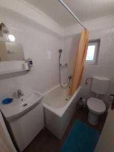 een badkamer met een wastafel, een bad en een toilet bij Házikó a Duna-parton in Ráckeve