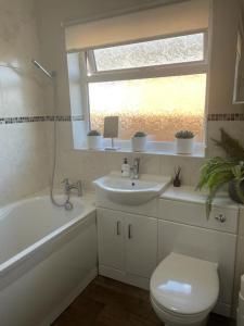 a bathroom with a sink and a toilet and a window at Number 3 in Penrhyn Bay