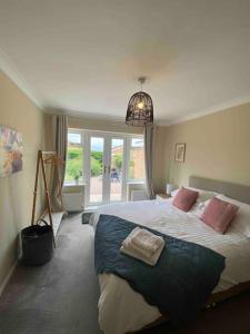 1 dormitorio con 1 cama grande con almohadas rosas en Number 3, en Penrhyn Bay