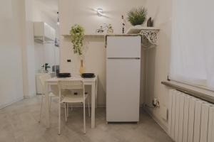 a kitchen with a table and a white refrigerator at City Center - Casa luxury in Ravenna