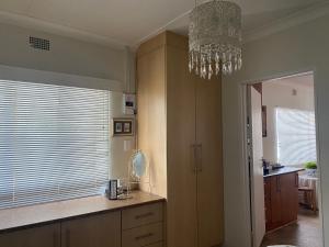 a kitchen with a chandelier hanging over a counter at Silver Linings Cottage in Parys +17 photos