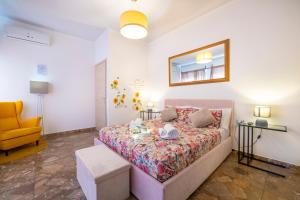 een slaapkamer met een bed en een gele stoel bij Borgo Trento Home, incantevole appartamento in Verona