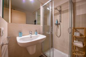 y baño con lavabo y ducha. en Borgo Trento Home, incantevole appartamento, en Verona