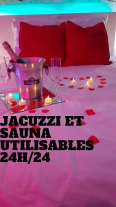 Una cama con una mesa con velas y copas de vino en Le Bijou Appartement avec Jacuzzi et Sauna privatif Terrasse plein sud Clim Parking Privatif, en Bandol