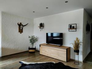 a living room with a flat screen tv on a dresser at Ferienwohnung Bergzauber in Maurach