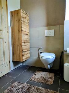 a bathroom with a toilet and a wooden door at Ferienwohnung Bergzauber in Maurach