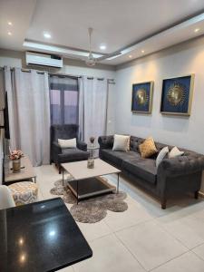 uma sala de estar com um sofá e uma mesa em Casa M- 1 bedroom apartment Aquaview complex em Bijilo