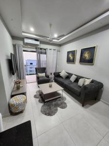 een woonkamer met een bank en een tafel bij Casa M- 1 bedroom apartment Aquaview complex in Bijilo