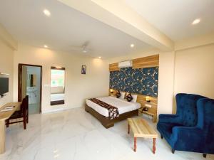 a bedroom with a bed and a blue chair at HOTEL THE CELEBRATION BY AMOD Best Hotel & Rooftop in Udaipur