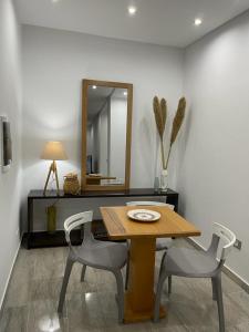 een eettafel met 2 stoelen en een spiegel bij Appartement l'aouina in El Aouina