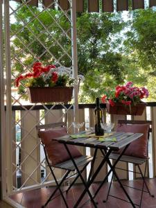 ローマにあるCasa Vacanze ELENAの花の咲くポーチにテーブルと椅子