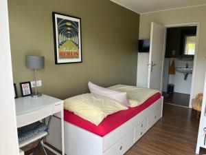 ein kleines Schlafzimmer mit einem Bett und einem Schreibtisch in der Unterkunft Bed Taste in Düsseldorf