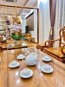 a tea set on a wooden table in a living room at Khách sạn Hoàng Sơn in Sơn La