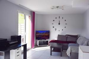 ein Wohnzimmer mit einem Sofa und einer Uhr an der Wand in der Unterkunft Chalet de la Thuile in La Thuile