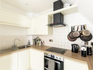 cocina con armarios blancos y fogones en Pass the Keys Modern 2 Bed in Leamington Spa, en Leamington Spa