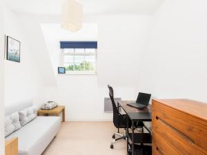 a living room with a couch and a desk with a laptop at Pass the Keys Modern 2 Bed in Leamington Spa in Leamington Spa