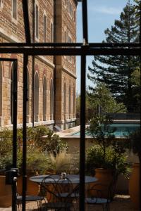 an outside view of a building with a table and chairs at Fourvi&egrave;re H&ocirc;tel in Lyon