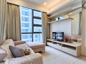 uma sala de estar com um sofá e uma televisão em Cozy Home The Robertson Gateway to Kuala Lumpur's Golden Triangle Bukit Bintang em Kuala Lumpur