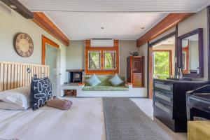 a bedroom with a bed and a dresser and a mirror at Hog Hollow Country Lodge in The Crags